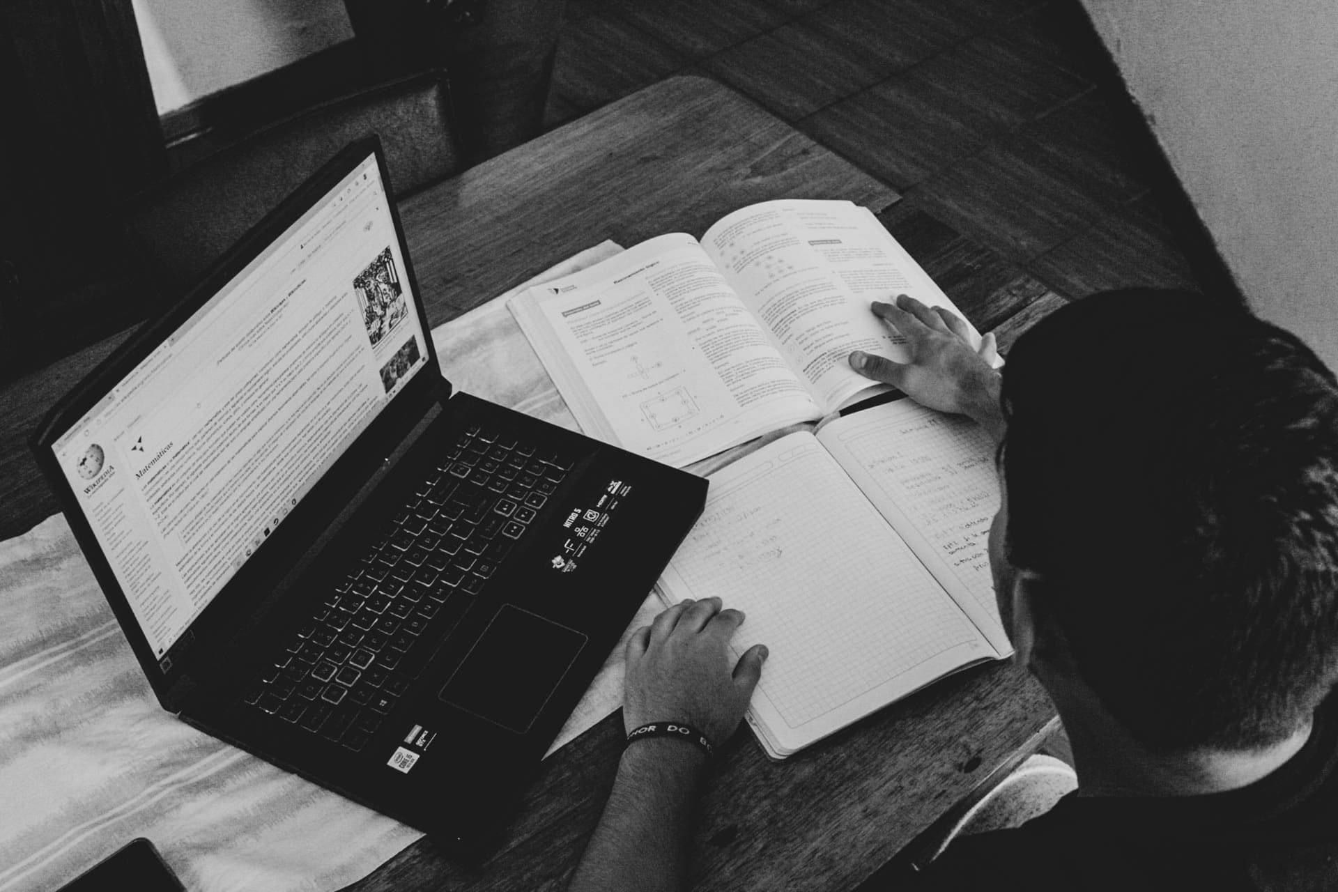 Student studying with laptop and textbooks the hard way