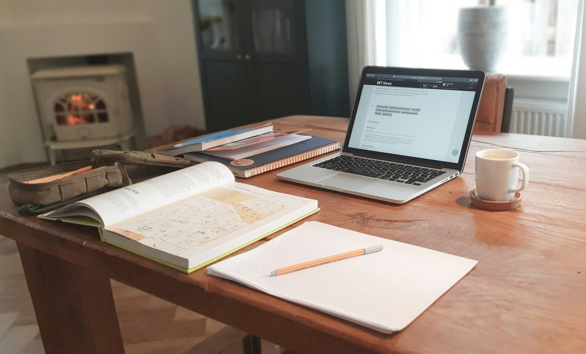 Cosy home study desk with open book, laptop and coffee